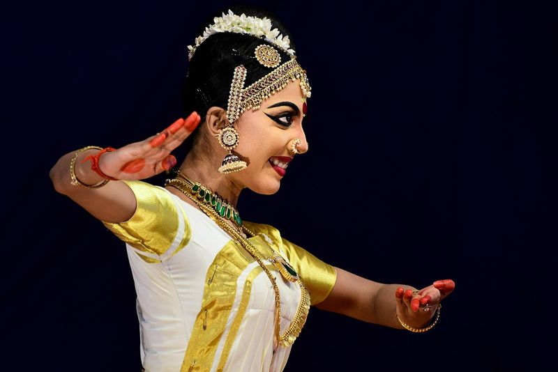 Mohiniyattam dancer in a white-and-gold Kerala costume performing at a school arts festival
