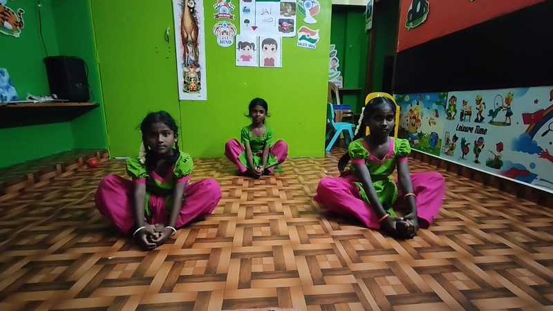 Three students seated on the floor during a Bharatanatyam class