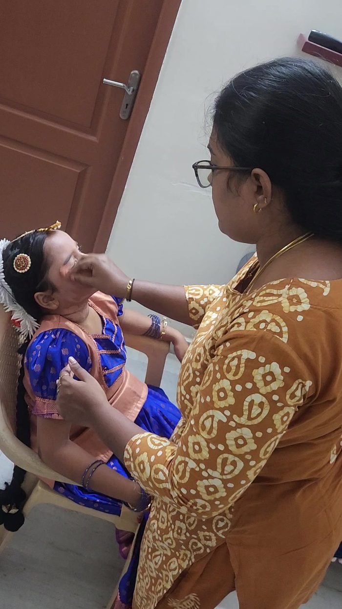 A young dancer having her make-up done before a performance